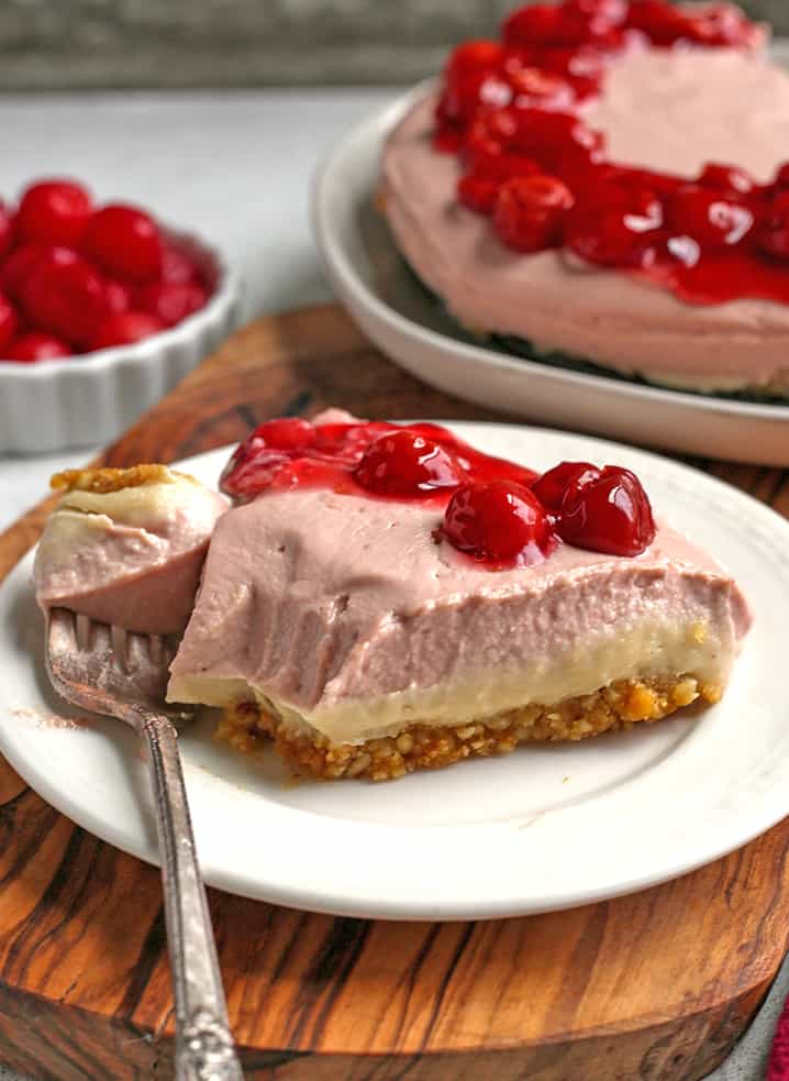 vegan paleo cherry cheesecake with a bite taken out. Bite is on fork next to the slice. 