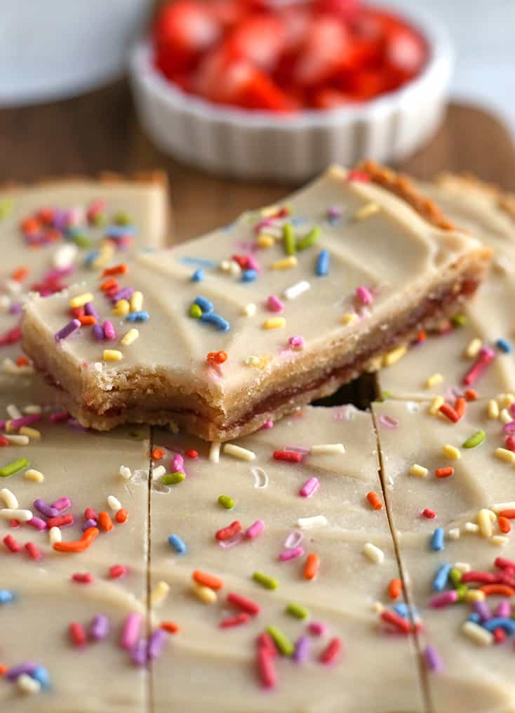 close up view of paleo strawberry pop tart bars with a bite taken out 