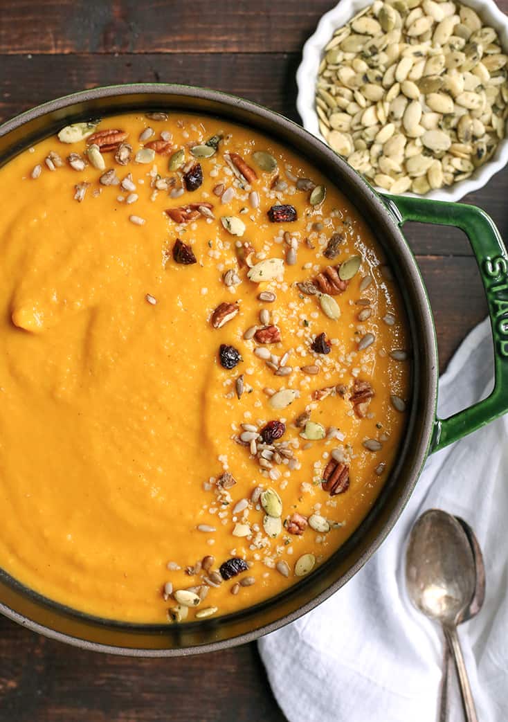 Butternut Squash Soup in a pan, topped with seeds and dried fruit. 