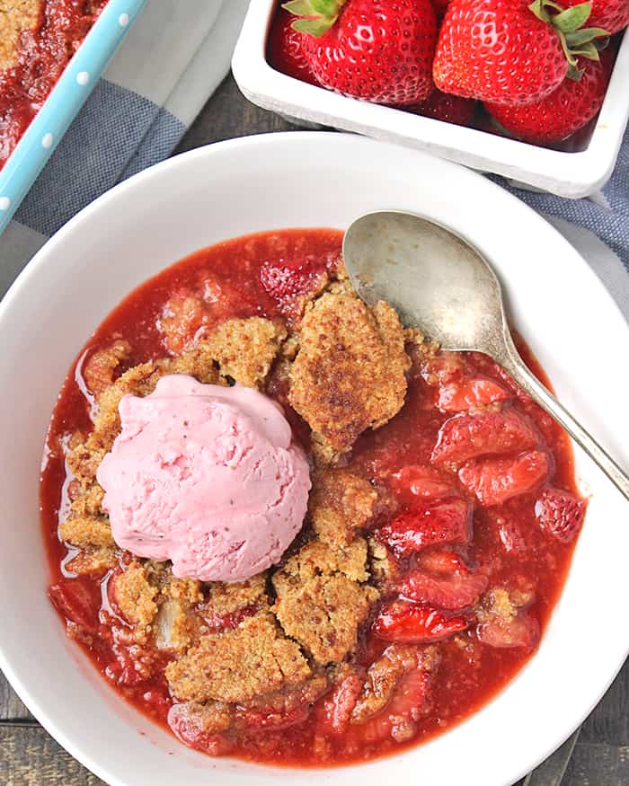 Strawberry Cobbler in a bowl with ice cream on top. 