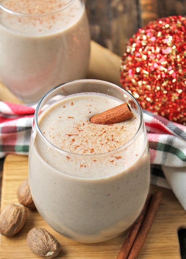 Homemade eggnog with a cinnamon stick in it and nutmeg sprinkled on top. 