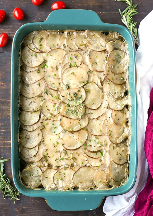 a big pan of scalloped potatoes with fresh thyme on top. 