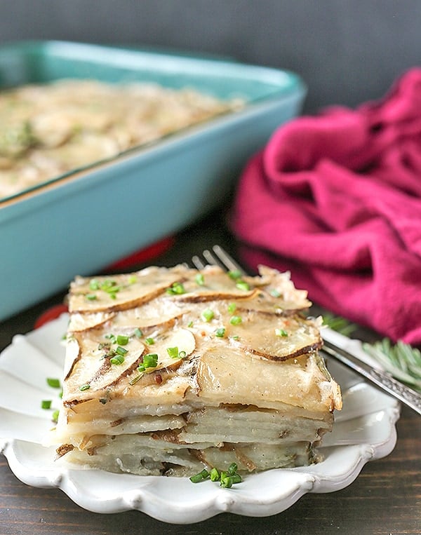 A serving of scalloped potatoes on a plate showing all the layers of potatoes. 