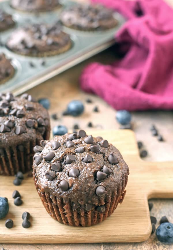 A couple paleo chocolate muffins on a small cutting board. 