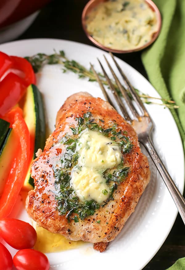 These Paleo Whole30 Pork Chops with Herbed Butter make a quick weeknight meal. Tender, juicy pork chops topped with an easy butter filled with fresh herbs. Gluten free, low carb, and keto.