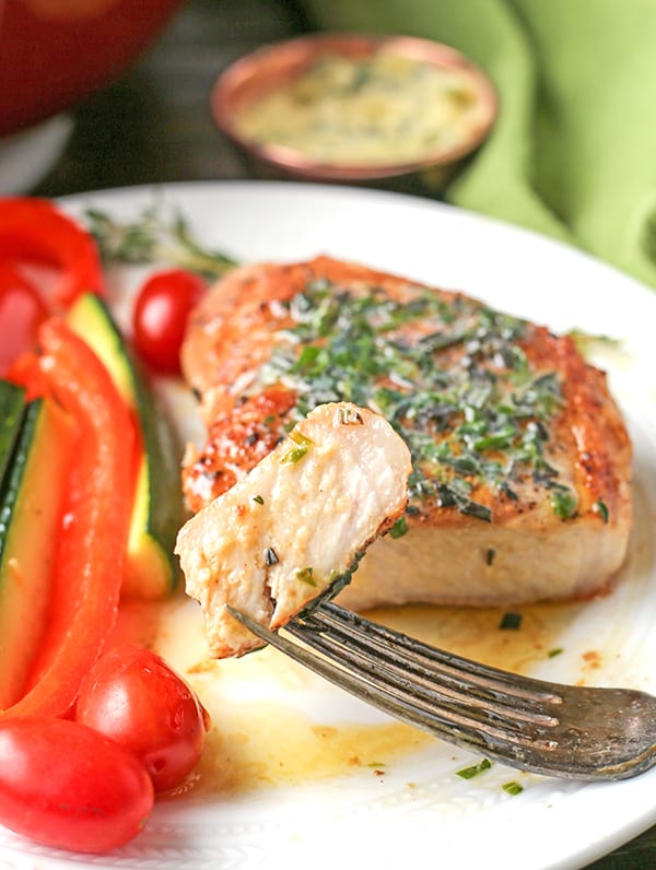 These Paleo Whole30 Pork Chops with Herbed Butter make a quick weeknight meal. Tender, juicy pork chops topped with an easy butter filled with fresh herbs. Gluten free, low carb, and keto.