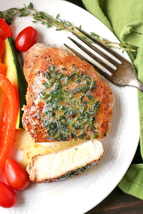 These Paleo Whole30 Pork Chops with Herbed Butter make a quick weeknight meal. Tender, juicy pork chops topped with an easy butter filled with fresh herbs. Gluten free, low carb, and keto.