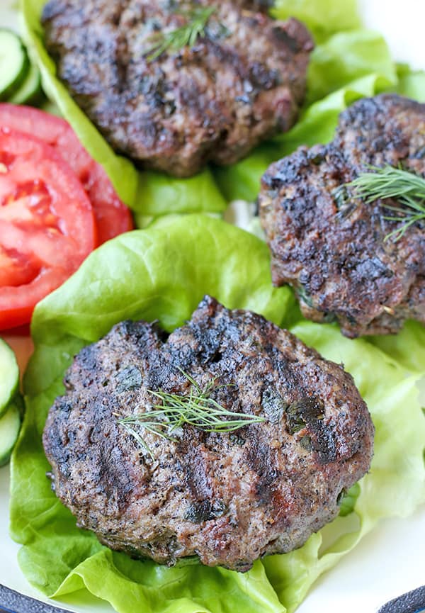 Gyro burgers on lettuce buns topped with dill. 