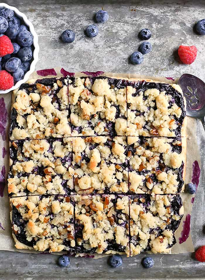 These Paleo Blueberry Pie Crumb Bars are simple to make and so delicious. A shortbread crust, thick layer of blueberries, and a crumble topping. These layered bars are gluten free, dairy free, vegan, and naturally sweetened.