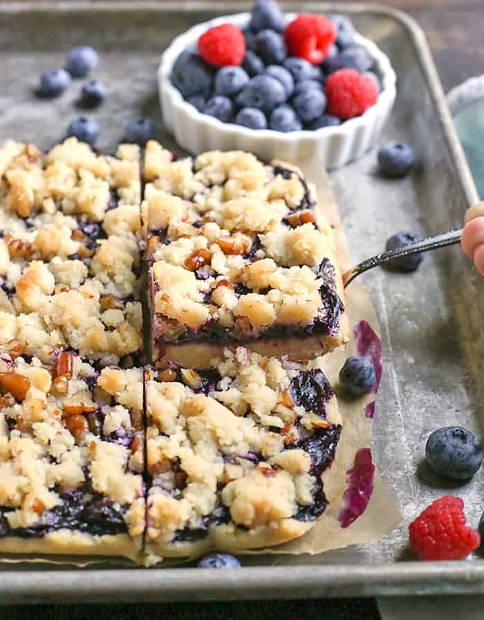 These Paleo Blueberry Pie Crumb Bars are simple to make and so delicious. A shortbread crust, thick layer of blueberries, and a crumble topping. These layered bars are gluten free, dairy free, vegan, and naturally sweetened.