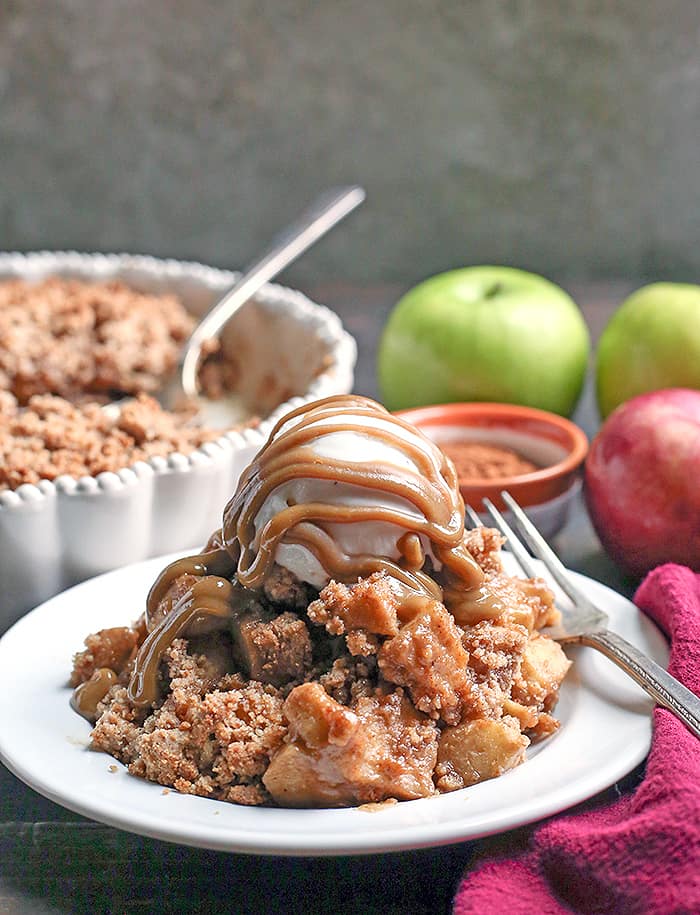 This Paleo Vegan Caramel Apple Crisp is the perfect fall treat! A simple caramel mixed together with the apples and topped with an irresistible crumb topping. Perfect with a scoop of dairy free ice cream and more caramel! It's gluten free, dairy free, and naturally sweetened.