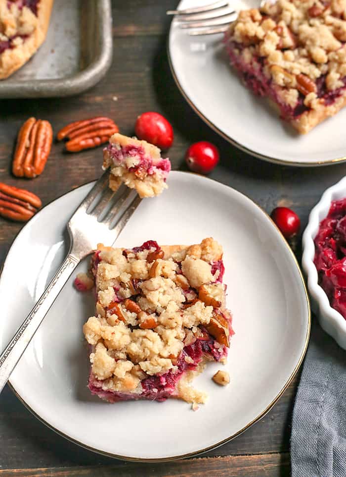These Paleo Vegan Cranberry Crumb Bars are simple to make and so delicious! A shortbread crust, thick layer of cranberry sauce and then a delicious crumb topping. They are gluten free, dairy free and naturally sweetened.