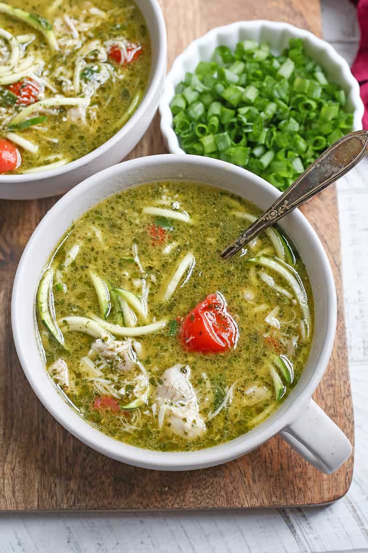 This Paleo Whole30 Pesto Chicken Zoodle Soup is quick, easy, and so delicious! Tender chicken, flavorful pesto, and perfectly cooked zucchini noodles make this so delicious. Gluten free, dairy free, and low FODMAP.