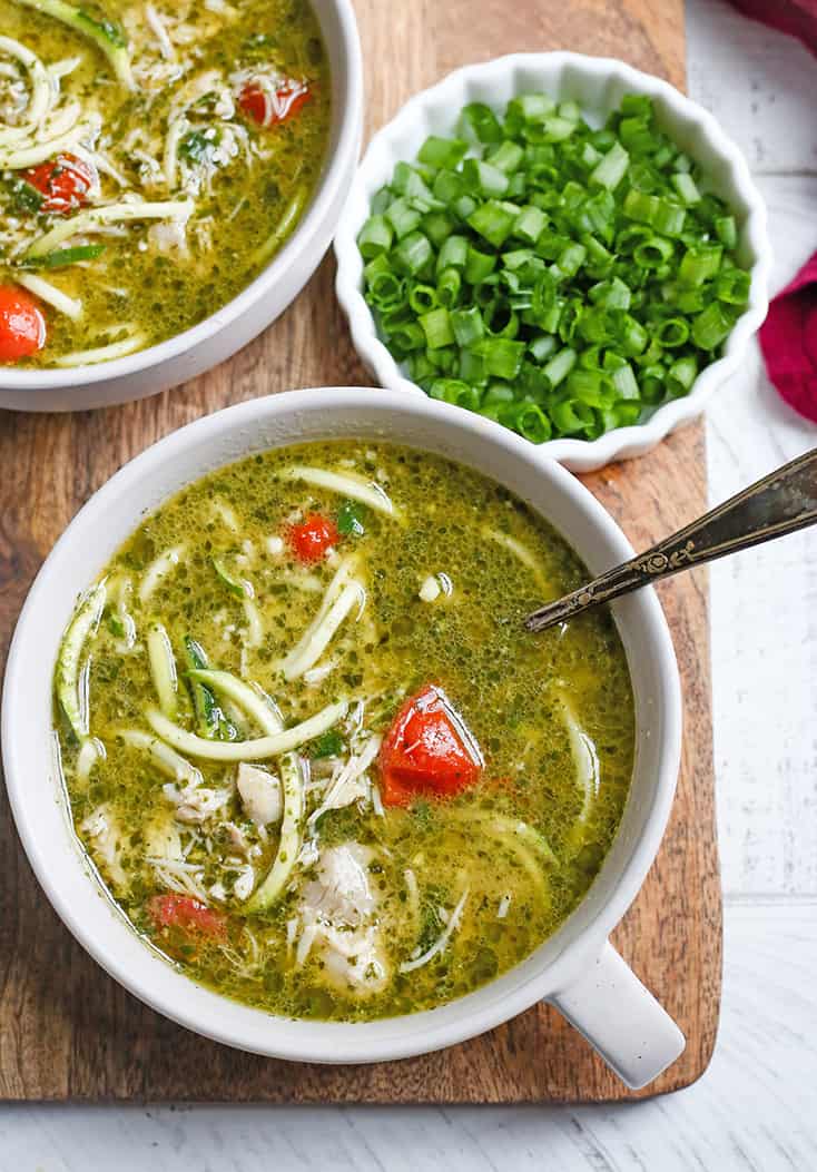 This Paleo Whole30 Pesto Chicken Zoodle Soup is quick, easy, and so delicious! Tender chicken, flavorful pesto, and perfectly cooked zucchini noodles make this so delicious. Gluten free, dairy free, and low FODMAP.