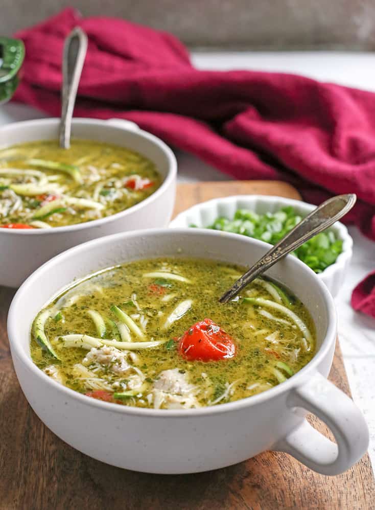 This Paleo Whole30 Pesto Chicken Zoodle Soup is quick, easy, and so delicious! Tender chicken, flavorful pesto, and perfectly cooked zucchini noodles make this so delicious. Gluten free, dairy free, and low FODMAP.