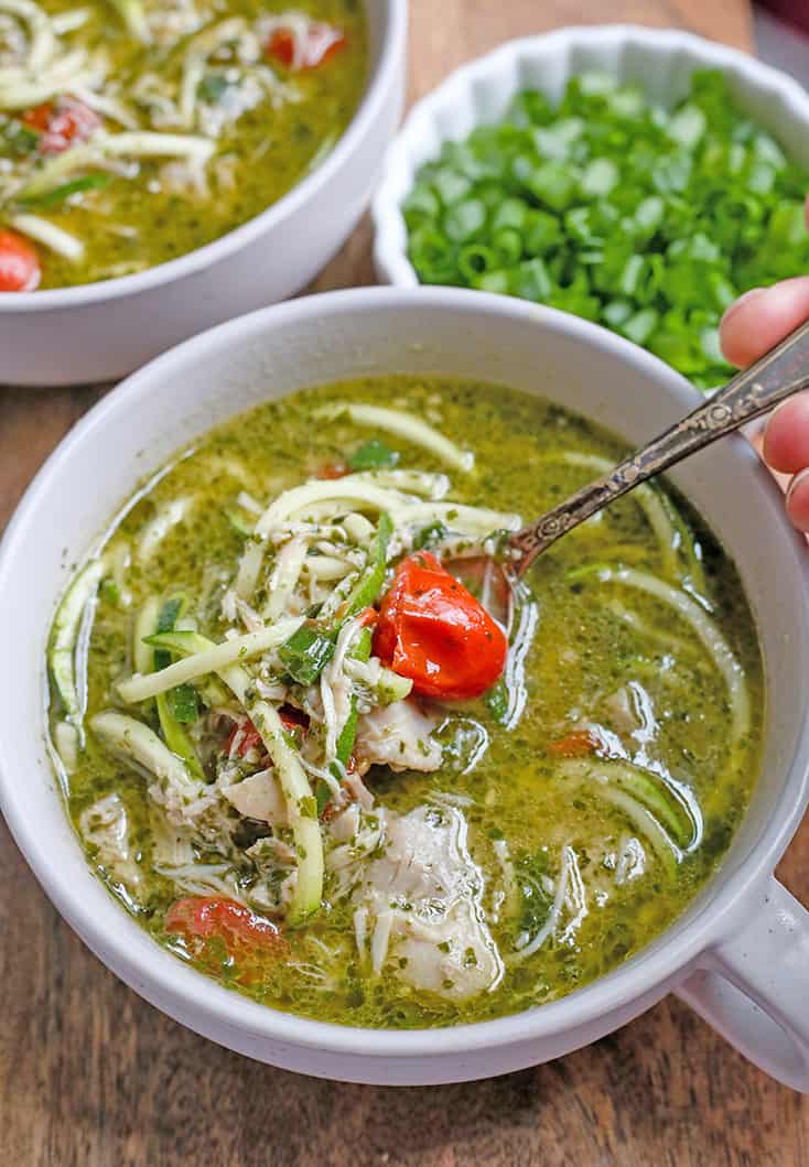 This Paleo Whole30 Pesto Chicken Zoodle Soup is quick, easy, and so delicious! Tender chicken, flavorful pesto, and perfectly cooked zucchini noodles make this so delicious. Gluten free, dairy free, and low FODMAP.