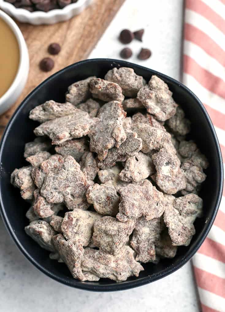 These Paleo Nut-Free Muddy Buddies (also known as Puppy Chow) are easy to make and so delicious. A chocolate and SunButter mixture poured over sunflower seeds and dusted with maple sugar. They are gluten free, dairy free, vegan, and naturally sweetened.