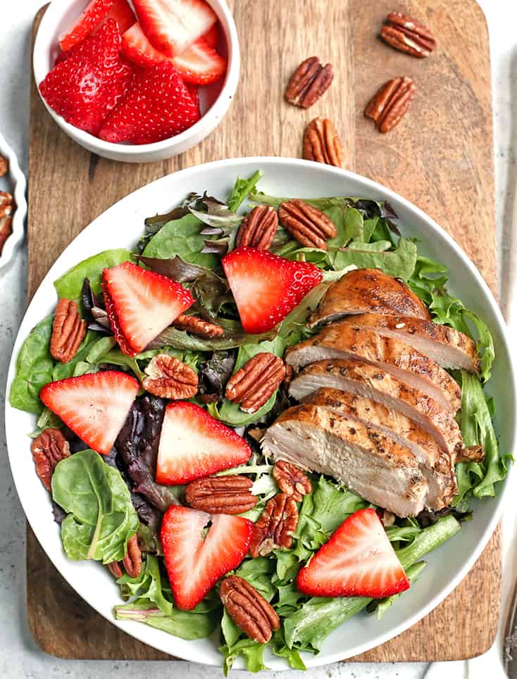 A bowl showing chicken and strawberry salad 