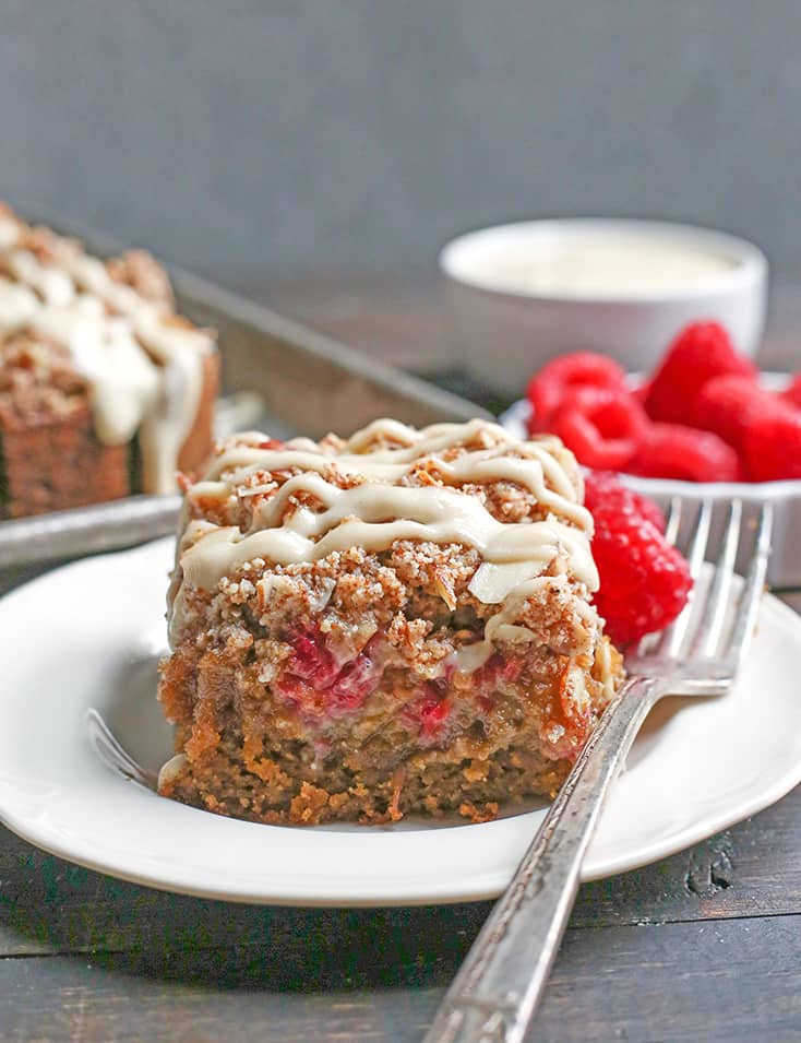 This Paleo Raspberry Cheesecake Coffee Cake tender, moist, and full of fresh raspberries. Topped with a dairy free cheesecake drizzle makes it even more amazing! It's gluten free, dairy free and naturally sweetened.