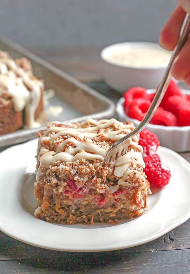 This Paleo Raspberry Cheesecake Coffee Cake tender, moist, and full of fresh raspberries. Topped with a dairy free cheesecake drizzle makes it even more amazing! It's gluten free, dairy free and naturally sweetened.