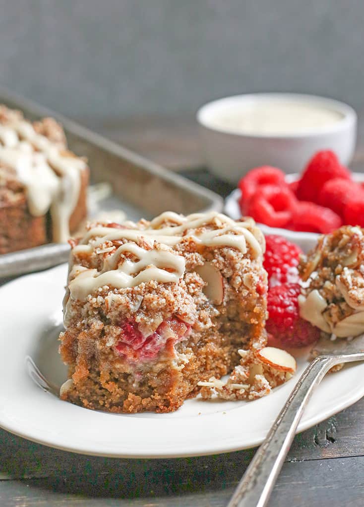 This Paleo Raspberry Cheesecake Coffee Cake tender, moist, and full of fresh raspberries. Topped with a dairy free cheesecake drizzle makes it even more amazing! It's gluten free, dairy free and naturally sweetened.