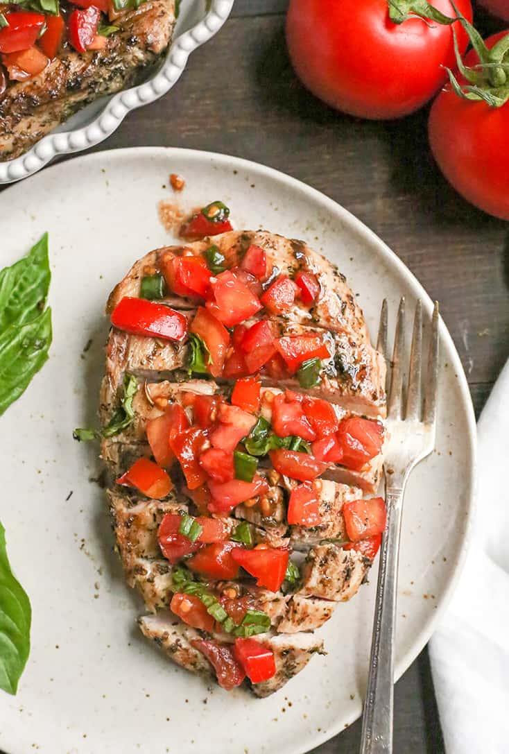 This Paleo Whole30 Bruschetta Chicken is easy and tastes amazing! A simple marinade for the chicken topped with a tomato balsamic mixture that is so flavorful. It's gluten free, dairy free, low carb and low FODMAP.