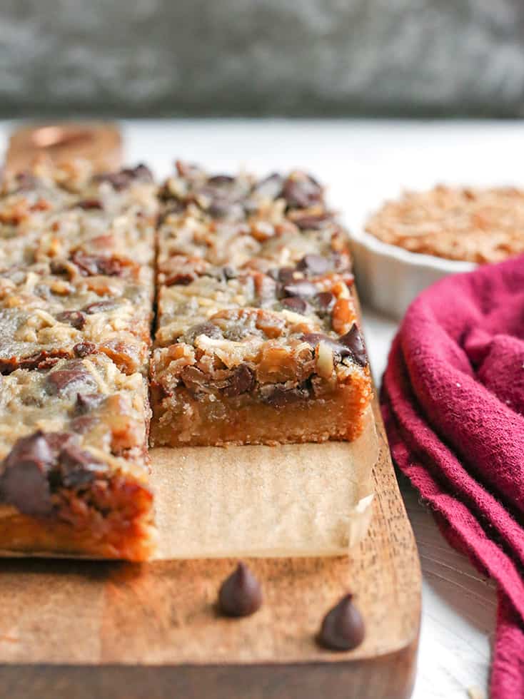 These Paleo Magic Cookie Bars are a healthier version of the classic dessert. A shortbread crust topped with shredded coconut, chopped pecans, chocolate chips and a homemade sweetened condensed milk poured on top. They are gluten free, dairy free, naturally sweetened with a vegan option.