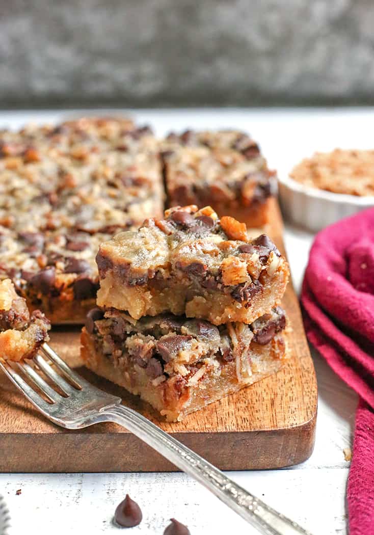 These Paleo Magic Cookie Bars are a healthier version of the classic dessert. A shortbread crust topped with shredded coconut, chopped pecans, chocolate chips and a homemade sweetened condensed milk poured on top. They are gluten free, dairy free, naturally sweetened with a vegan option.