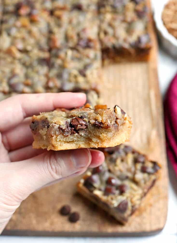 These Paleo Magic Cookie Bars are a healthier version of the classic dessert. A shortbread crust topped with shredded coconut, chopped pecans, chocolate chips and a homemade sweetened condensed milk poured on top. They are gluten free, dairy free, naturally sweetened with a vegan option.