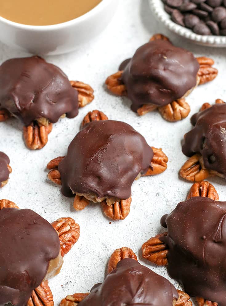These Paleo Vegan Pecan Turtles are simple to make, no-bake, and so tasty. A healthy version of the classic candy. Sweet caramel on top of crunchy pecans and topped with chocolate. They are gluten free, dairy free, low FODMAP and naturally sweetened. 