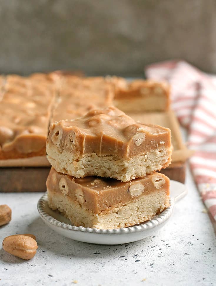 These Paleo Caramel Cashew Bars are easy to make, rich, and so good! A shortbread layer topped with a fudge-like layer that is sweet and packed with buttery cashews. They are gluten free, dairy free, vegan, and naturally sweetened.