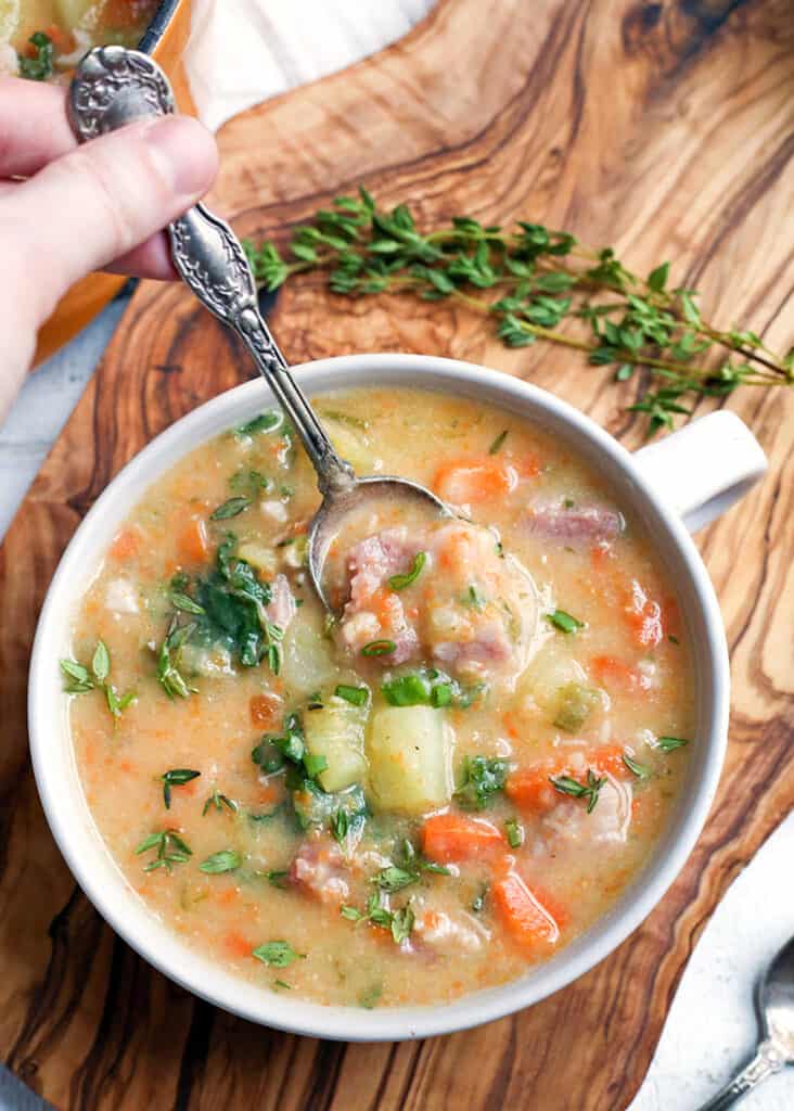 ham and potato soup with a spoon taking a bite