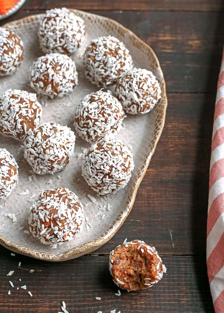 plate of carrot cake balls with one with a bite out of it