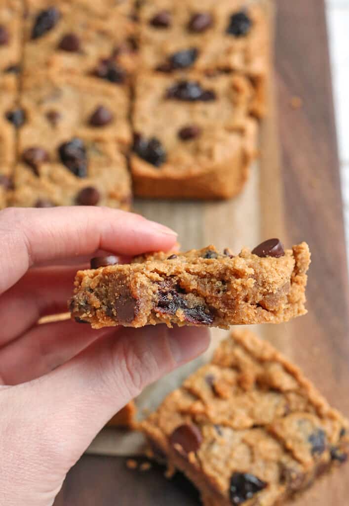 paleo cherry chocolate chip bar being held with a bite taken out of it 