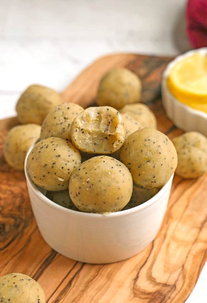 a bowl of lemon poppy seed bites with a bite taken out of one