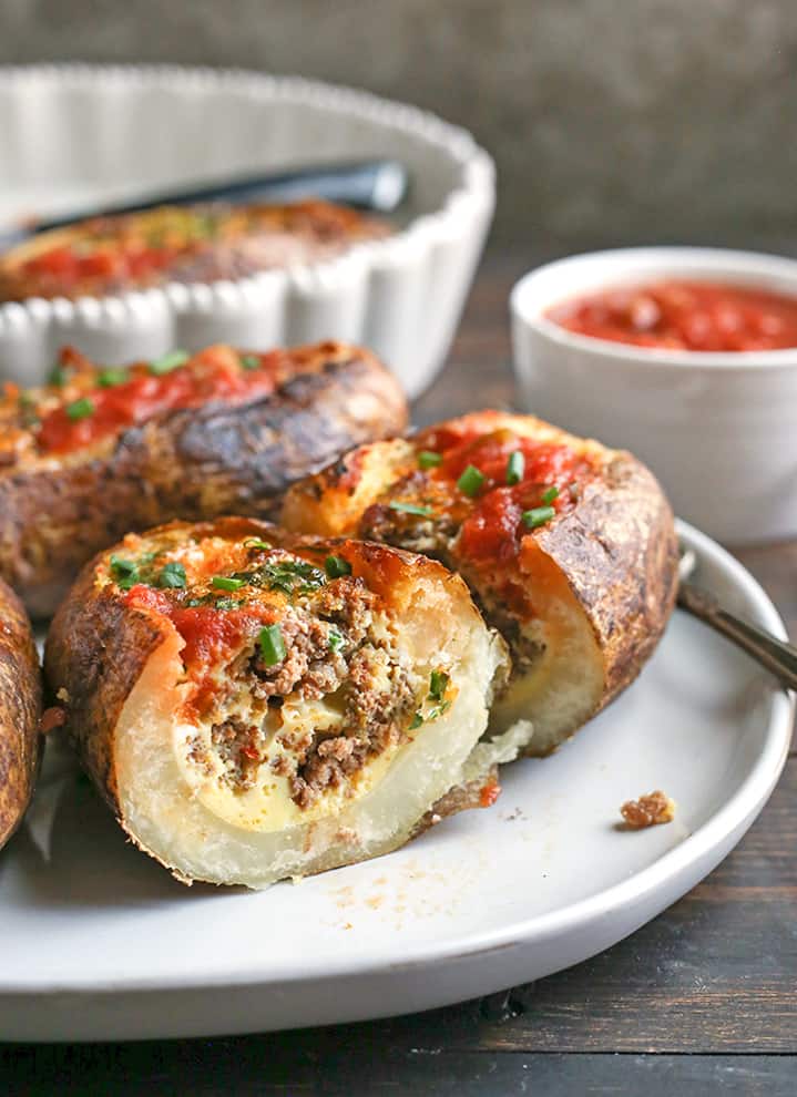 cut potato showing taco meat and egg, topped with salsa