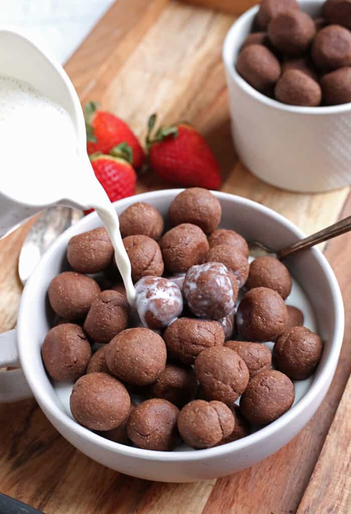 paleo nut free cocoa puffs, almond milk being poured on