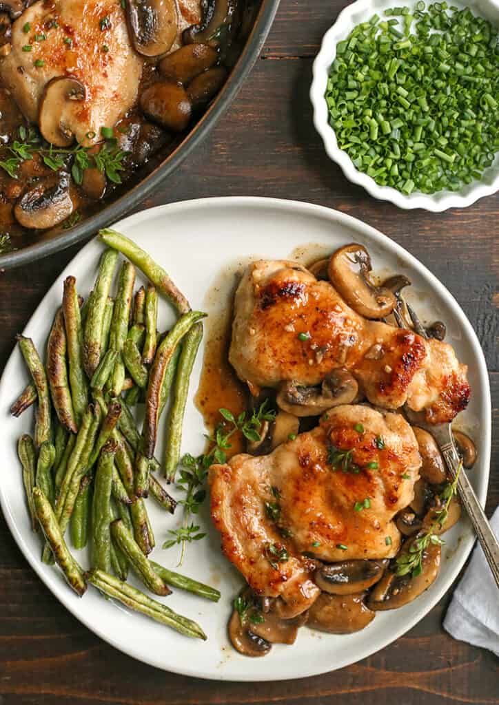 paleo creamy mushroom chicken on a plate with green beans