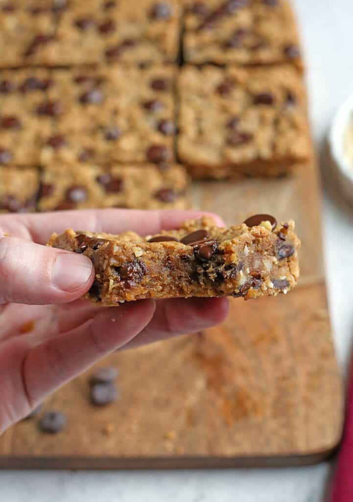 paleo oatmeal cookie bars being held with a bite taken out of it