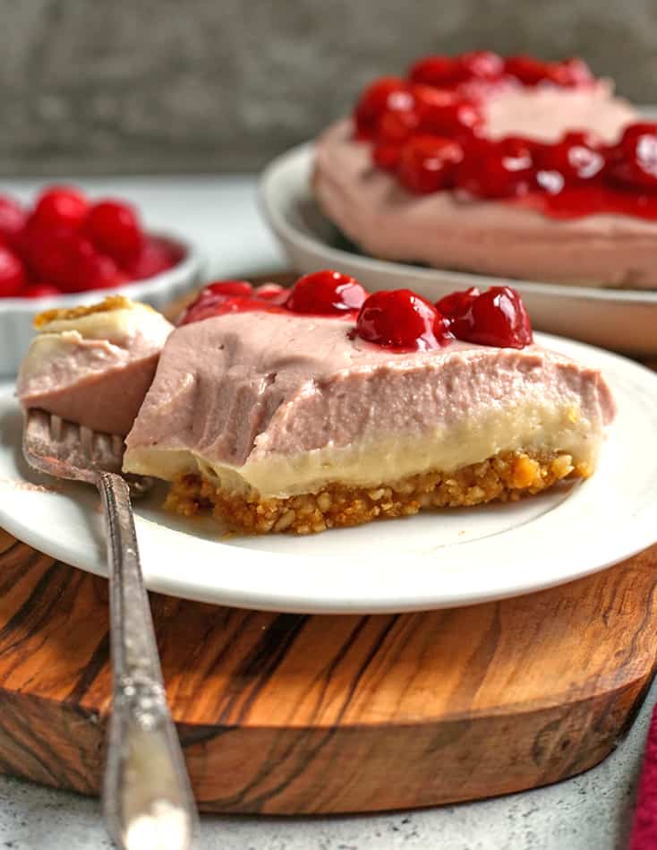 paleo vegan cherry cheesecake slice on a plate with a bite taken out