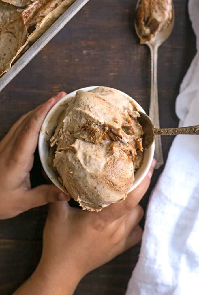 paleo cinnamon roll ice cream in a bowl with little hands holding it