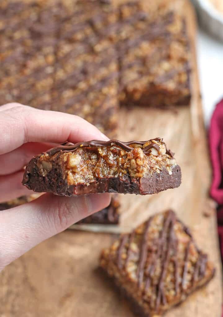 hand holding a german chocolate brownie with a bite taken out