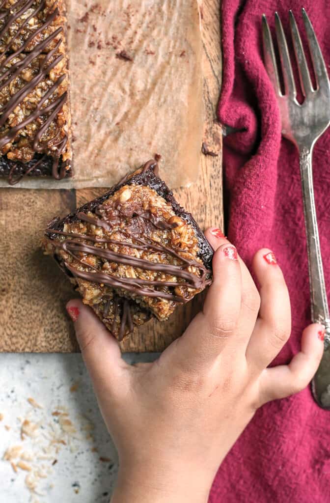 little hand grabbing a paleo vegan german chocolate brownie