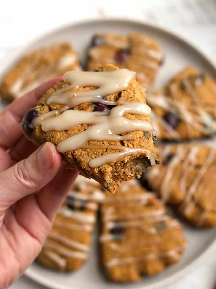 hand holding a paleo blueberry scone with a bite taken out