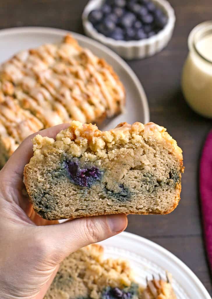 hand holding a piece of paleo blueberry streusel bread 