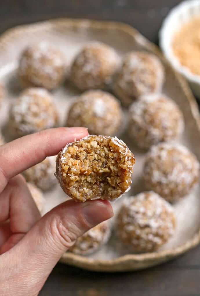 a hand holding a paleo coconut cashew bite 