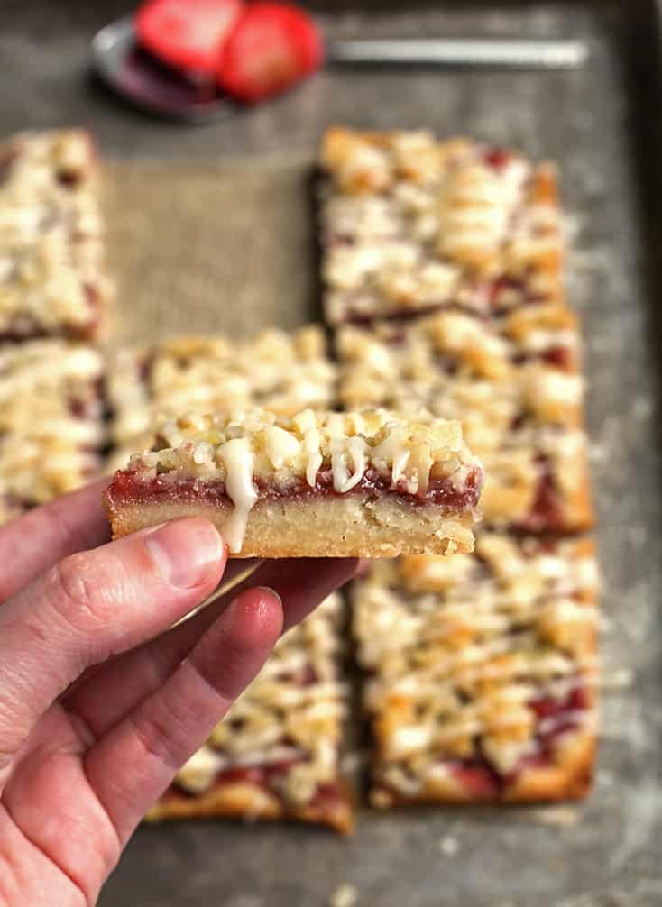 hand holding a paleo strawberry crumb so the layers are showing 