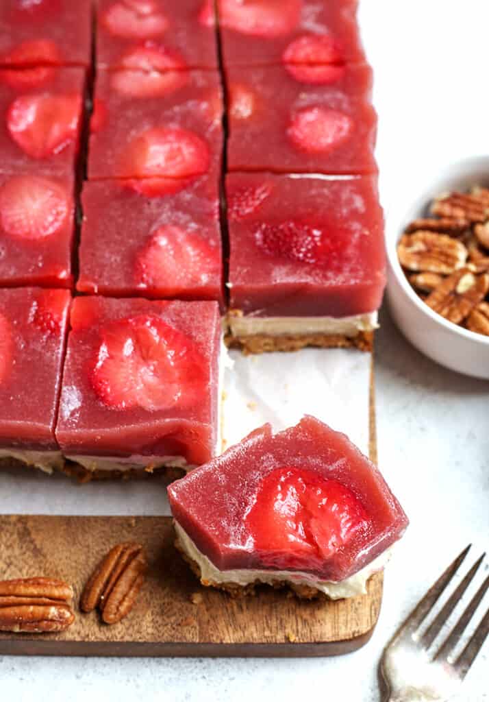 paleo strawberry pretzel salad pieces, one with a bite taken out