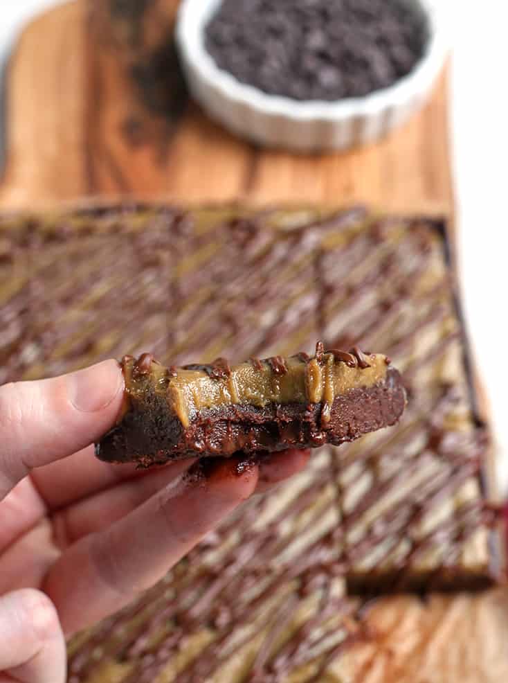 hand holding a vegan buckeye brownie with a bite taken out of it