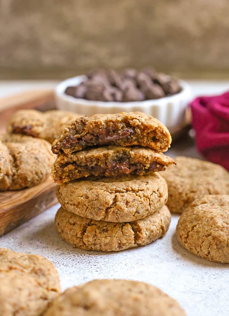 a stack of paleo chocolate stuffed cookies with the chocolate center showing